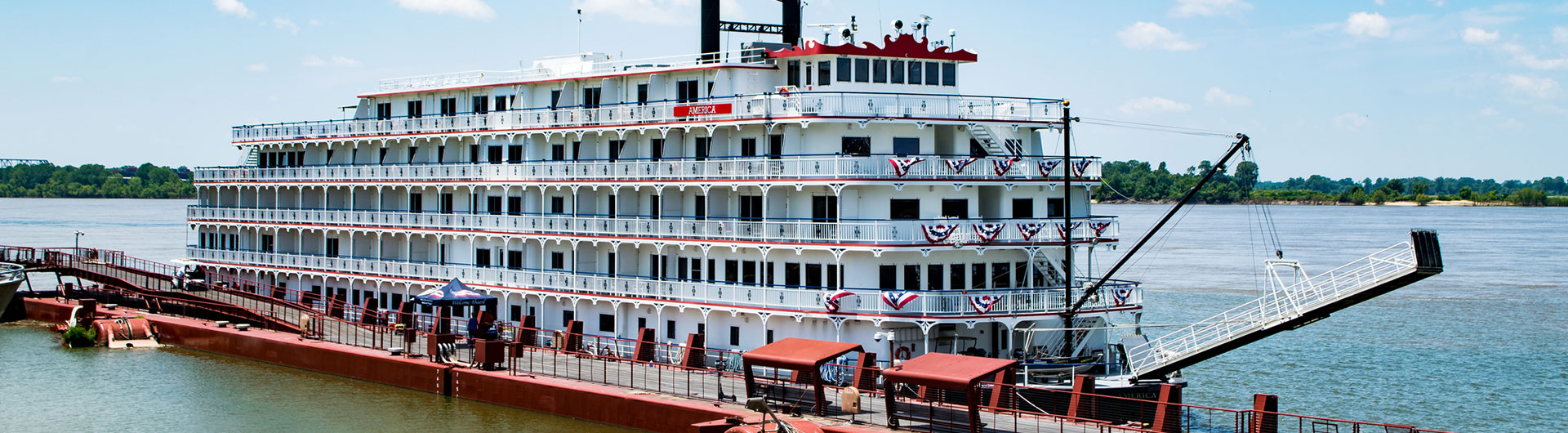Large multi-deck paddlewheeler moored at a riverside landing
