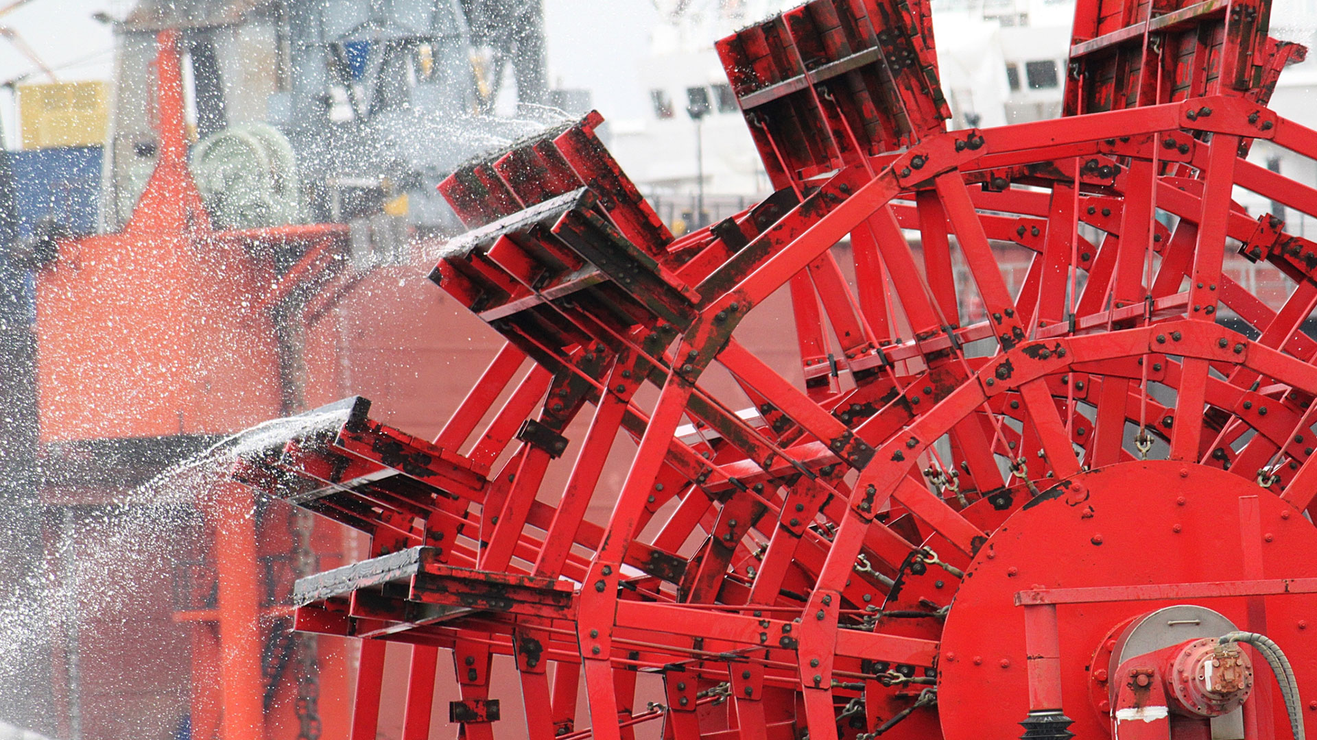 Close-up of a red sternwheel throwing off spray